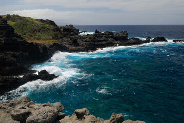 Fototapeta na wymiar Lava rocks shore and crashing waves at Mokolea Point Maui