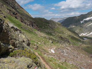Summer view of alpine mountain valley with Stubai hiking trail, Stubai Hohenweg, rock, boulders and river stream. Tyrol Alps, Austria