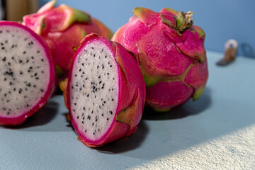 Pitaya fruits or dragon fruit in halves on blue background