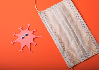 Coronavirus and medical mask on the second wave. Made from paper. Bright background. Free space.