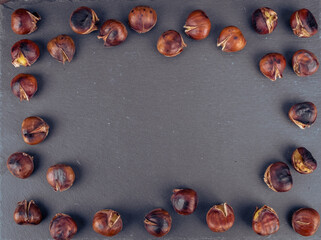 Chestnuts in a pan on a wooden background. Rustic style