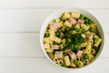 Italian pasta ditalini with peas, herbs and cheese, in a white plate