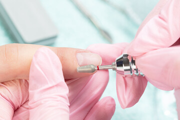 Manicure process, cleaning nails with a milling cutter, close up.	
