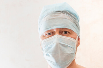 Full face portrait of male doctor in cap and mask close up