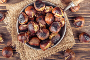 Chestnuts in a pan on a wooden background. Rustic style