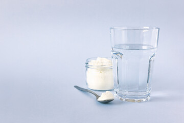 Collagen powder and a glass of water. Healthy lifestyle. Natural beauty and health supplement. Copy space.