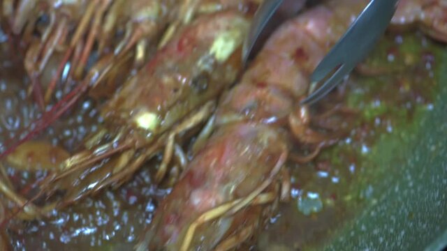 Restaurant chef fries shrimps in pan in olive oil and soy sauce. HD