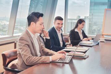 Businesspeople use computer notebook in meeting room