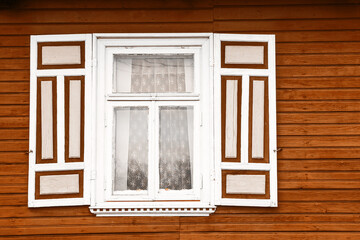 Obraz na płótnie Canvas Wooden window rustic cottage house. Vintage wall with transparent glass window and decorative brown and white shutter. Countryside architecture background.