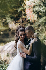 Photo session of the newlyweds against the backdrop of a picturesque area. Forest and rocks.