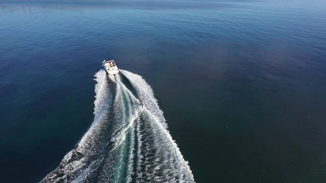 Aerial view of speedboat with wakeboard rider into the sea
