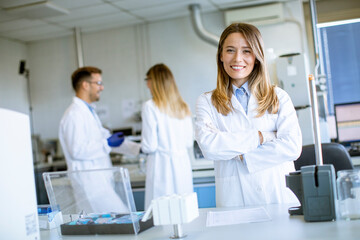 Obraz premium Female scientist in white lab coat standing in the biomedical lab