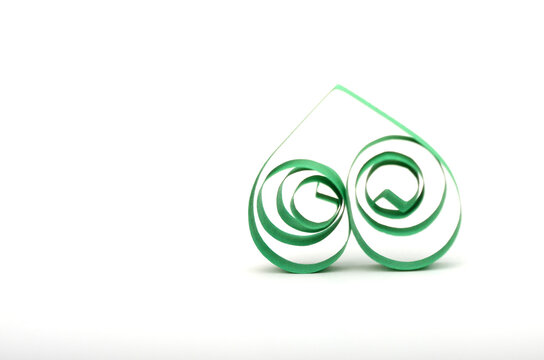 A green quilling paper heart on white