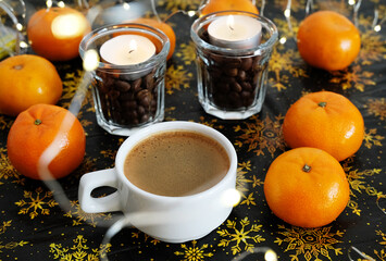Cup of coffee on christmas pattern background. Mandarines and coffee candles in glasses. Garland lights