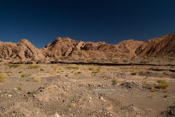 The Andes mountain range. View of the desert, sand and brown mountains under a deep blue sky.