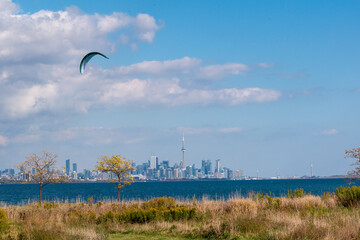 A parasurfer surfs in Lake Ontario in Colonel Samuel Smith Park with the Downtown Toronto, Ontario...