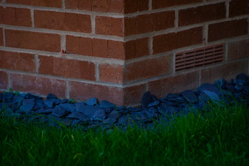 Front Garden Design of a house - Brick Wall Edge with Grey Stones And Grass