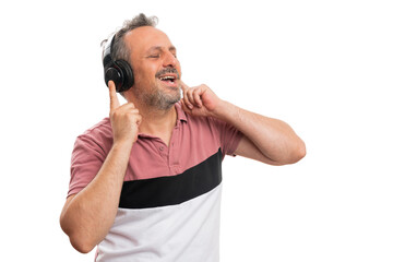 Adult male model smiling as listening to music in headphones