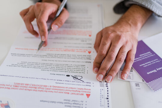 close up of hands completing absentee ballot