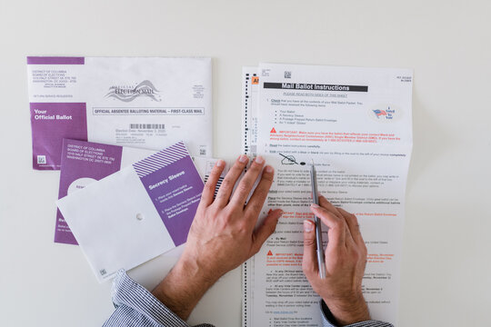 close up of man carefully completing mail in ballot