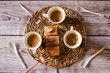 Tres tazas de café sobre fondo rústico, pasteles sobre la mesa, visto desde arriba