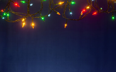 Christmas lights on blue background with copy space