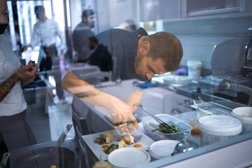 Young chef is preparing a typical dish of the restaurant. She brings to the table good and tasty cuisine