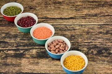 Assorted Legumes: mung beans and red , yellow lentils on wooden background