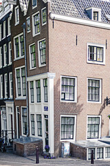 Amsterdam traditional dancing corner house on a bright summer day. Travel architecture.