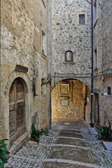 Fototapeta na wymiar A narrow street among the old stone houses of Castro dei Volsci, a medieval village in the province of Frosinone in Italy.