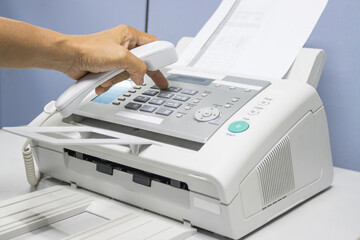 hand man are using a fax machine in the office, equipment for data transmission. - obrazy, fototapety, plakaty