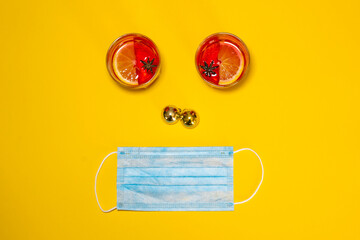 Overhead shot of a one-sided composition with glasses of mulled wine, Christmas balls, and a surgical mask. Concept of celebrating Christmas during the Covid-19 pandemic. Copy space