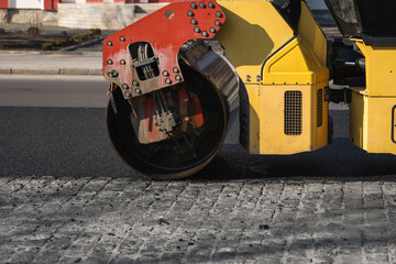 Asphalt road roller with heavy vibration roller compactor press new hot asphalt on the roadway on a road construction site. Heavy Vibration roller at asphalt pavement working. Repairing.