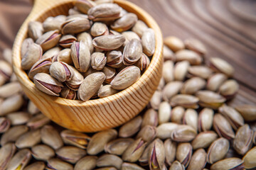 Pistachios in a Cup on a wooden background.  Place for text. Nuts close up