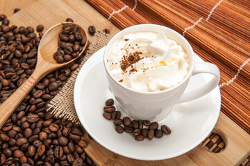 cup of aromatic coffee with coffee beans and whipped cream