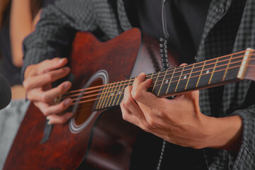 Close up shot hands of guitarist perform with his acustic guitar