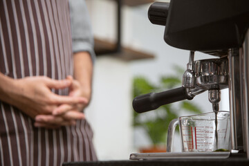 Barista waiting beverage pouring from machine