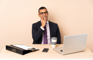 Young business man in his office with a laptop and other documents nervous and scared