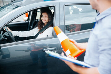 Positive experience in driving school. Cheerful confident young woman is glad for improvement of...