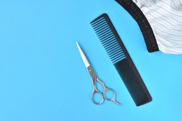 Clipper and hairdressing scissors and comb on background. Hairdresser tools with selective focus on blue  background. 