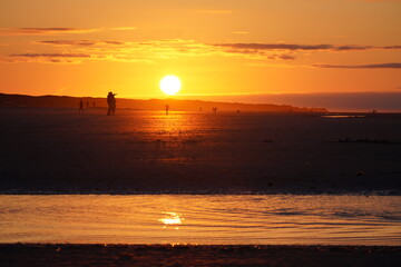Fototapeta na wymiar Glaring Red Sunset on the Beach of Juist
