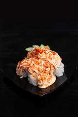 japanese norimaki roll topped with sliced kani spice mayonnaise,