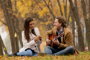 Happy couple having picnic in a park, fall season