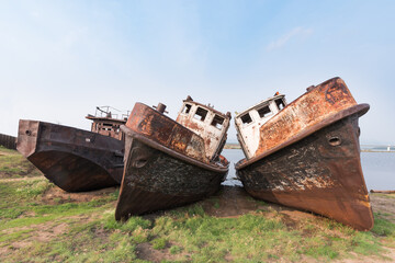Rusty metal hulls of river vessels stand on the banks of the Barguzin River near the Barguzinsky Bay of Baikal, the largest freshwater lake in the world.  © ANDREI