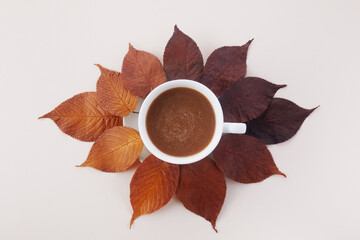 Cup of coffee with autumn leaves. Autumn decor, fall mood