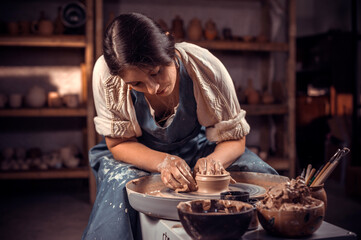 Stylish young lady demonstrates the process of making ceramic dishes using the old technology. Handiwork.