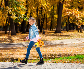 Fototapeta premium Happy little girl in an autumn park