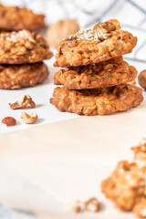 Homemade oat cookies with various nuts and sesame seeds close-up. Free space for text. Tasty and healthy dessert, vegetarian and vegan food.