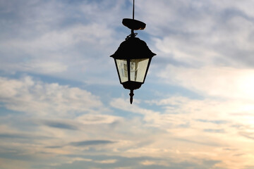 Fototapeta na wymiar Outdoor lantern and cloudy sunset sky. Selective focus.