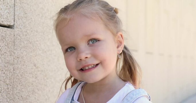a little girl pulls her fingers in her mouth. girl shows her teeth